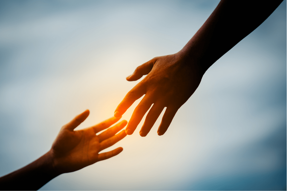 Hands reaching for each other indicating a willingness to help one another.